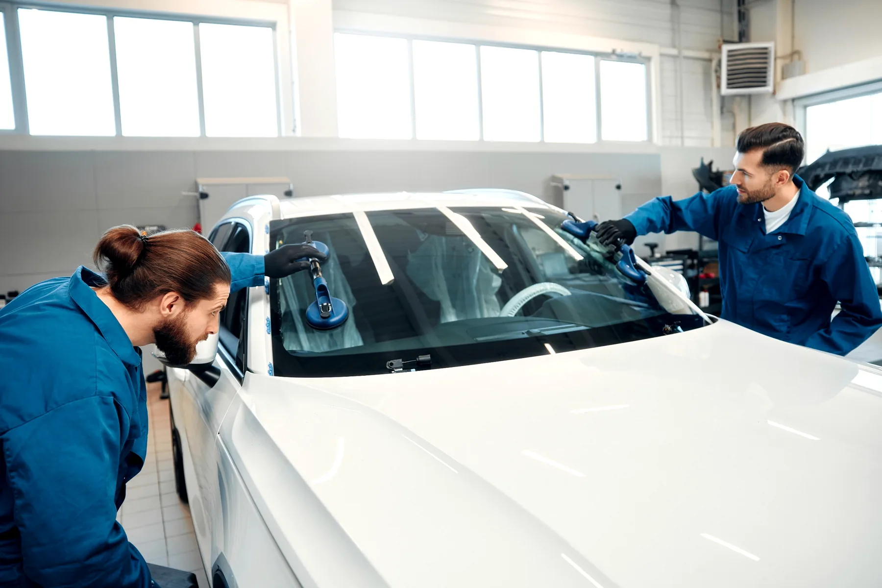 Auto glass technician preparing replacement glass